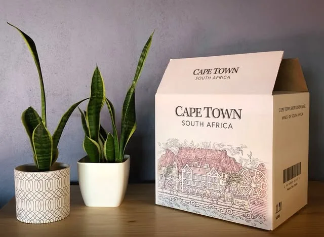 A Cape Town South Africa wine carton beside potted plants